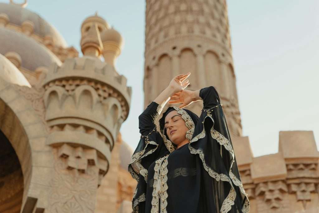 Neutraal Dubai vrouw die handen in de lucht heeft nabij prachtig midden oosten gebouw